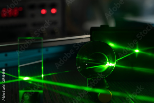 Green laser on optical table in a quantum optics lab.