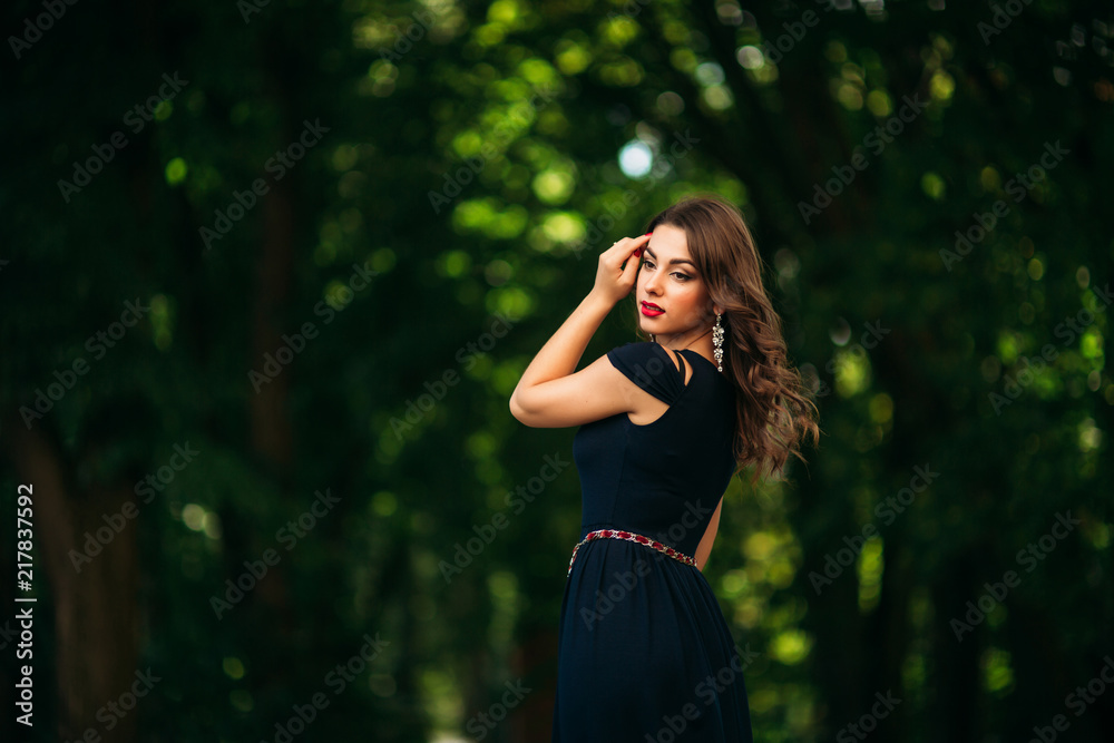 A beautiful girl in a blue dress is walking in the park. Sunny day. Summer A beautiful girl in a blue dress is walking in the park. Sunny day. Summer