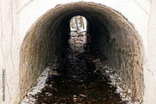 old gray concrete tunnel with water flow