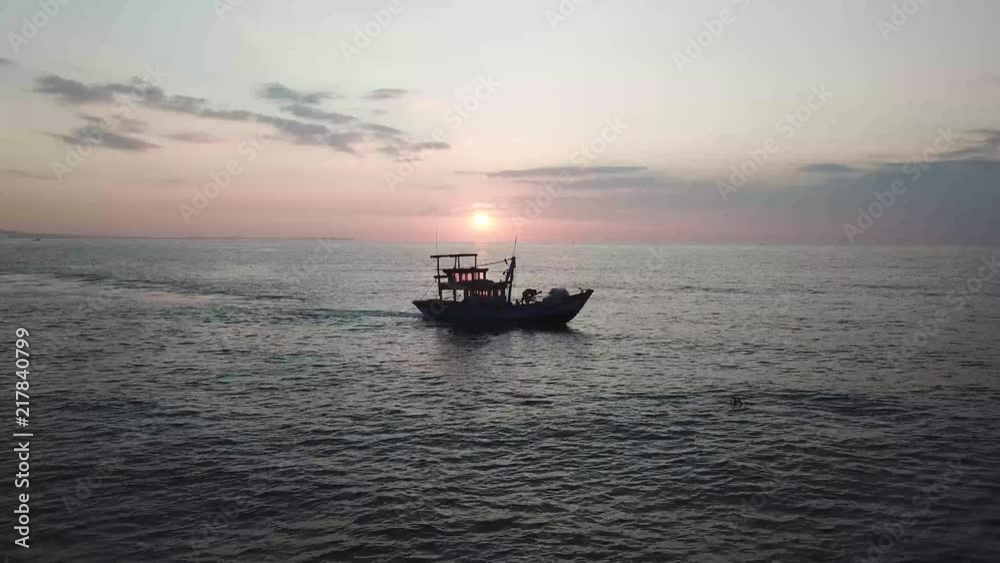 working fisherman on a boat in the Pacific Ocean of Vietnam with a beautiful sunrise in the background. working fisherman on a boat in the Pacific Ocean of Vietnam with a beautiful sunrise in the background.