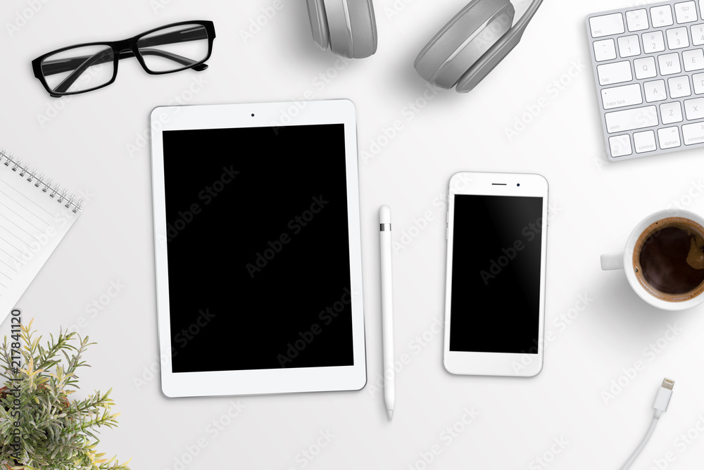 Tablet and phone on office desk. Blank screen for mockup, app or responsive web site presentation. Flat lay.
