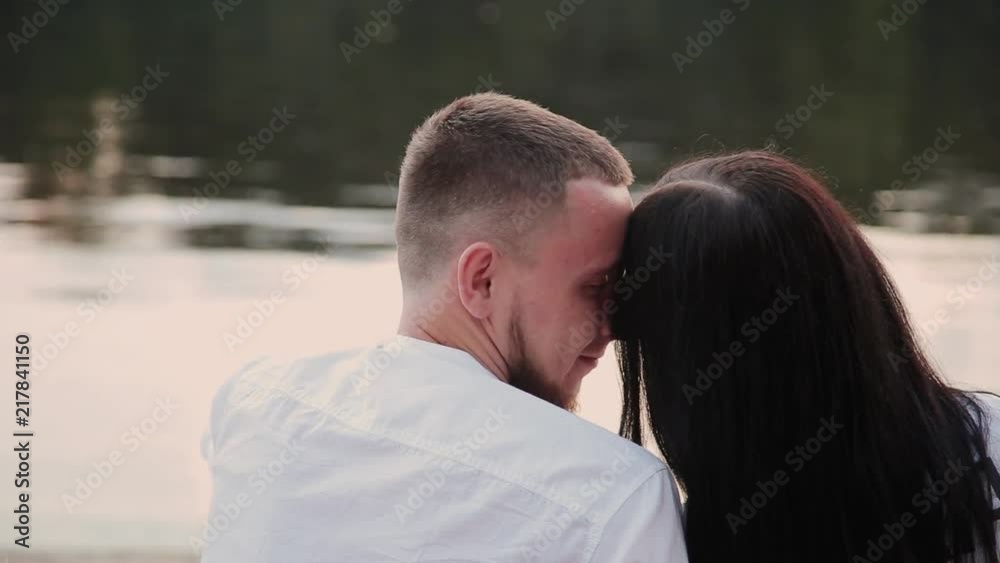 Loving couple sitting on the beach and hugging, sunset. Loving couple sitting on the beach and hugging, sunset.
