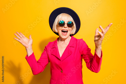 Tablou pe pânză Party on! Portrait of wondered and happy old lady in hat and red