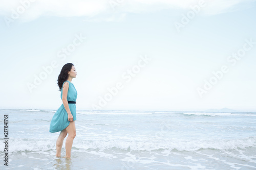 Young beautiful asian woman is walking along the beach