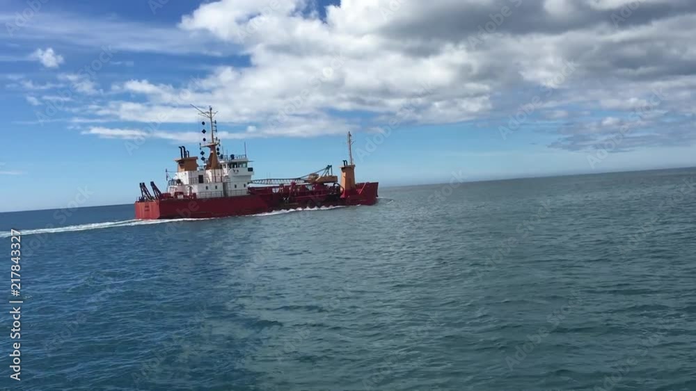 Red Ship passing by in the ocean Red Ship passing by in the ocean