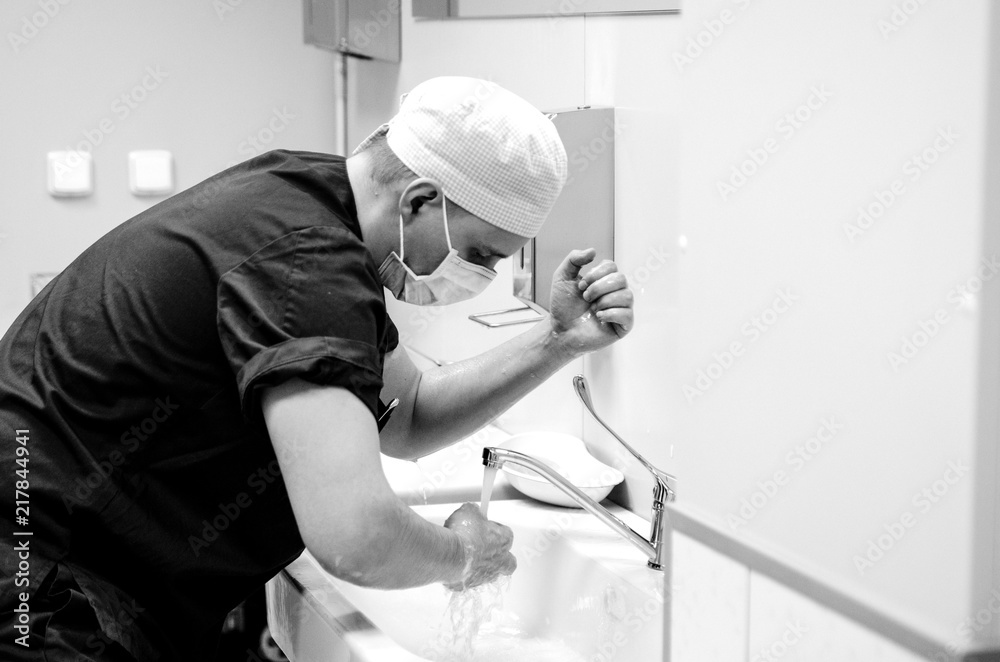 The doctor washes his hands with soap before starting the operation.
