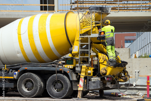 Construction site worker washing concrete truck