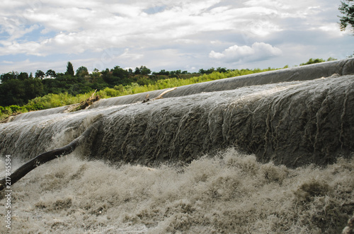 the river flows over a dam with large waves