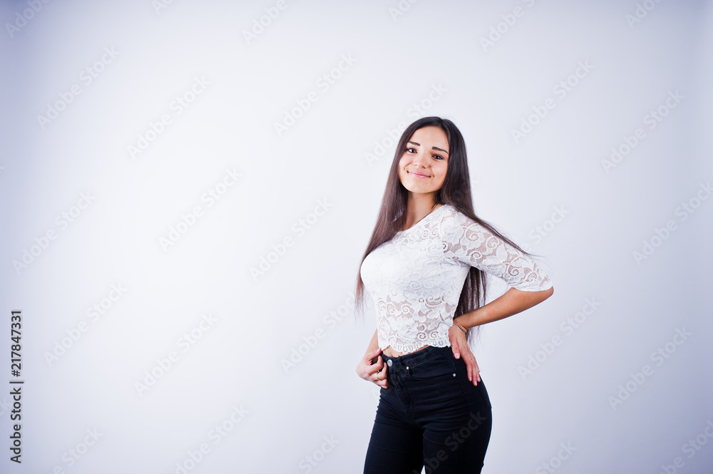 Portrait of an elegant young woman in white top and black pants in the studio. Portrait of an elegant young woman in white top and black pants in the studio.