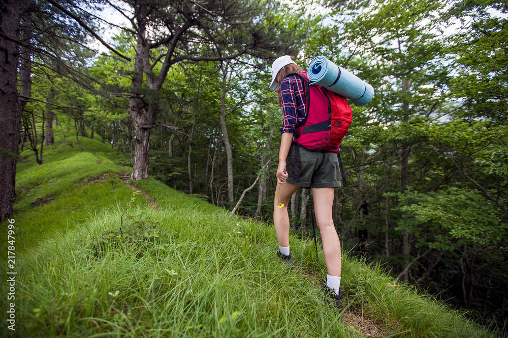 Obraz premium Female hiker with backpack exploring forest