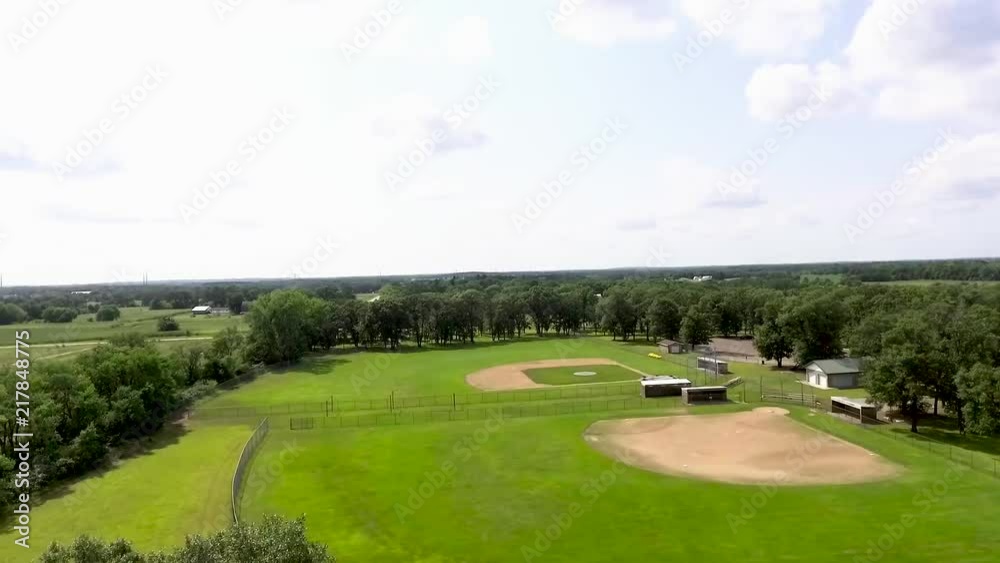 Aerial perspective from the sky looking down on a public ball park with a softball field and a baseball field from a side view of the two fields. Camera pans left to right. Aerial perspective from the sky looking down on a public ball park with a softball field and a baseball field from a side view of the two fields. Camera pans left to right.