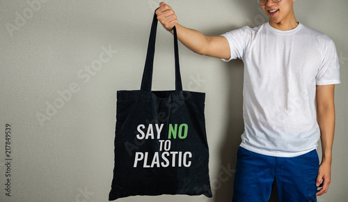 Say no to plastic text on tote bag carrying by man