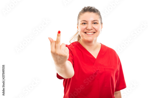 Young medical nurse wearing red scrub showing middle finger gesture.