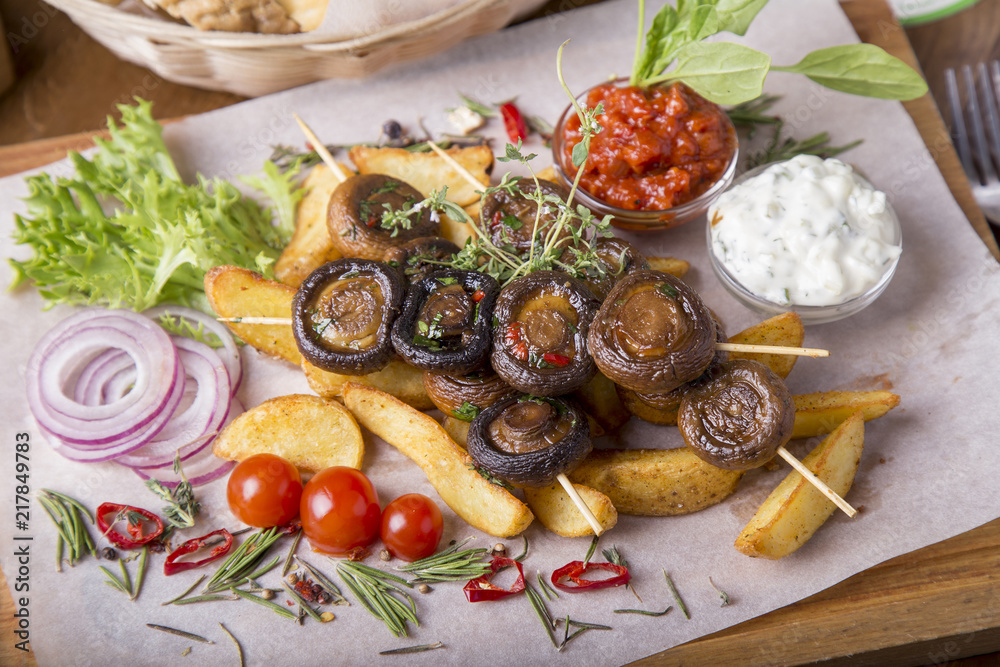 Appetizing vegetables cooked on the grill.  Barbecue mushrooms and fried potatoes