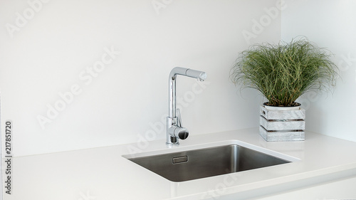 Modern kitchen sink and faucet with decorative flowers. photo