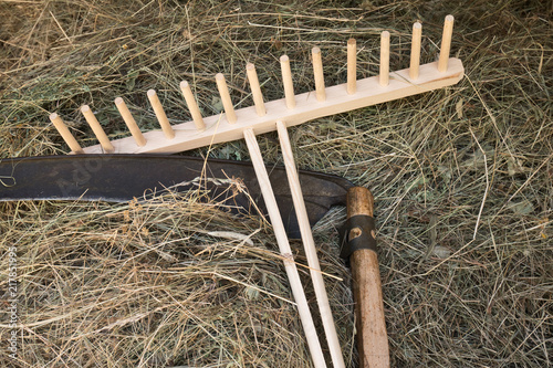 Bild auf Leinwand A scythe and a rake with  hay