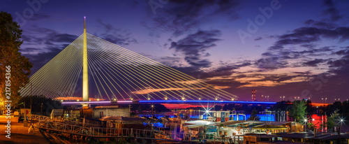 Belgrade panorama Ada bridge Sava River by night, boats and colorful reflection on water photo