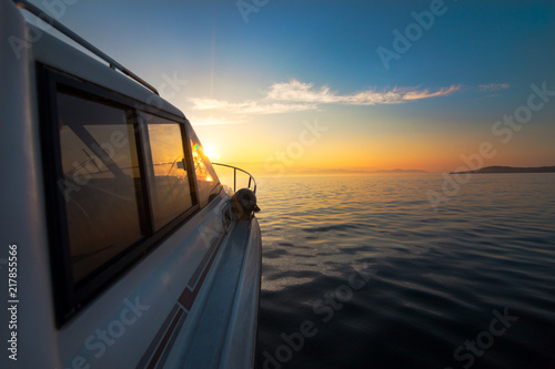 Motorboat moving to sunset © yo camon