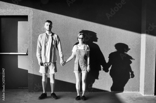 Black and white shot of Young couple near parking wall photo