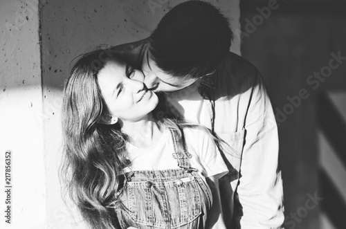 Black and white shot of Woman receiving kiss from her boyfriend on the parking photo