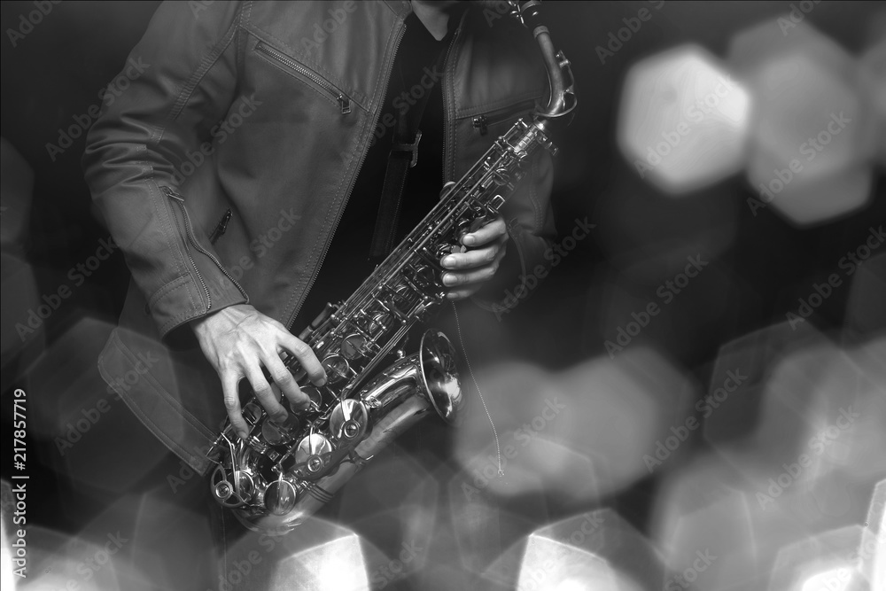Obraz premium Saksofonista jazzowy w wykonaniu na scenie. Dodano filtr kolorów i sześciokątny efekt bokeh.