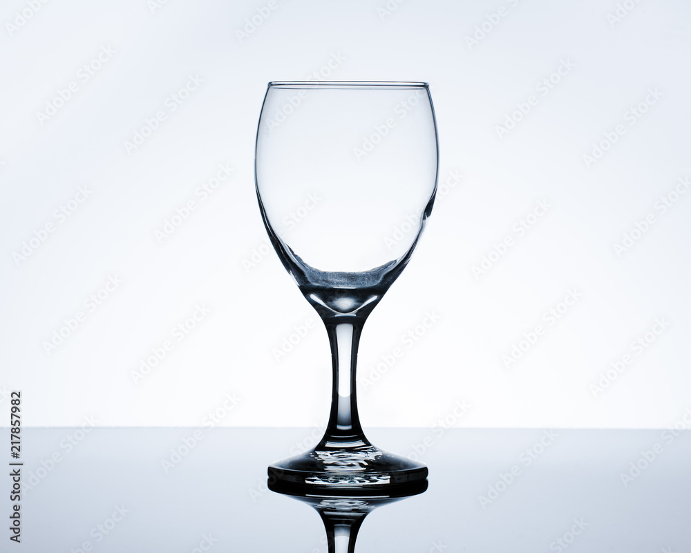 Empty wine glass on table. Backlit studio image. Empty wine glass on table. Backlit studio image.
