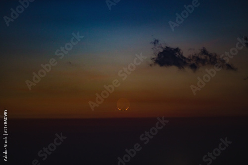 Young Moon photographed from southern hemisphere above the ocean   sea horizon.