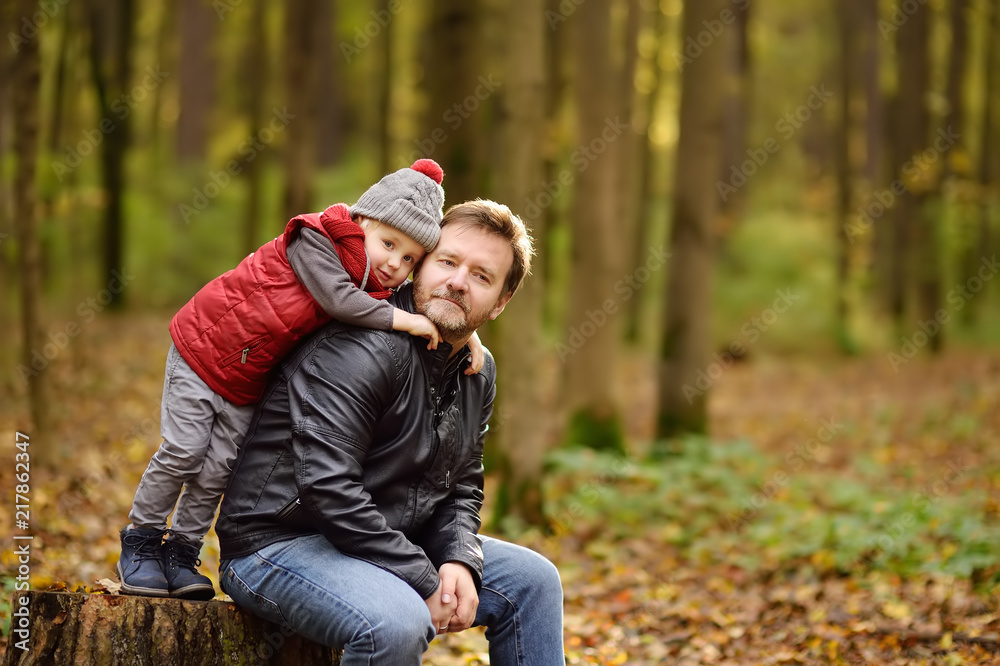 Little boy with his father during stroll in the forest