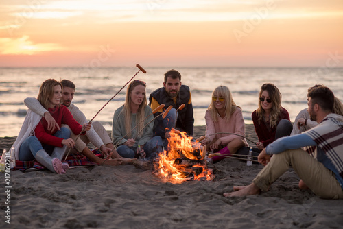 Group Of Young Friends Sitting By The Fire at beach