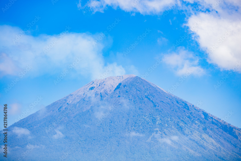 Mount Agung with smoke from the crater and clouds above, july 2018, couple of weeks after last eruption with lava.