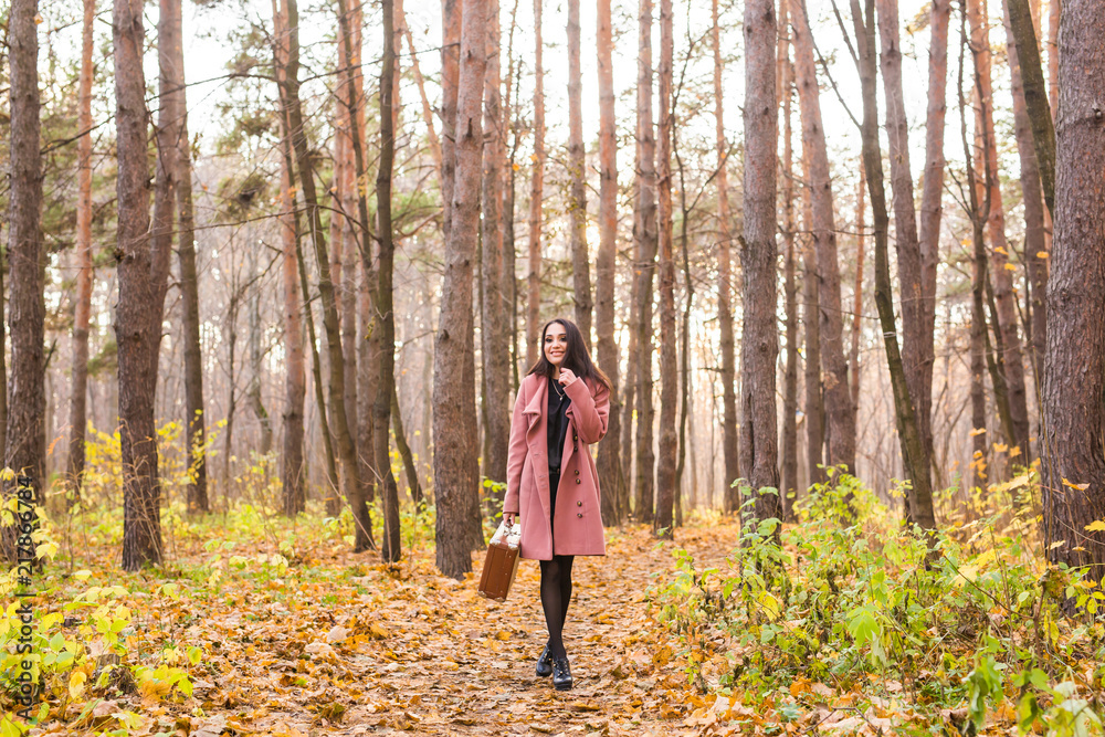 Season, nature and people concept - Woman in autumn park posing with suitcase Season, nature and people concept - Woman in autumn park posing with suitcase
