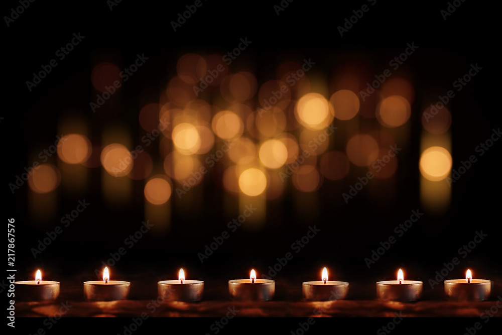Burning candles with festive golden bokeh