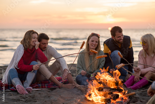 Group Of Young Friends Sitting By The Fire at beach