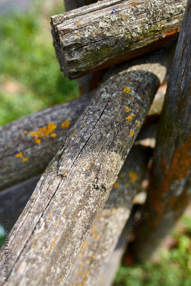 Surface of old wooden sticks arranged herringbone. Wooden fence close up background. Old wooden fence on the sand. Surface of old wooden sticks arranged herringbone. Wooden fence close up background. Old wooden fence on the sand.