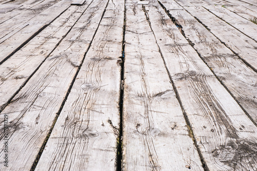 White boardwalk of stripped weathered washed out wooden planks with scratches in perspective. Abstract natural texture background