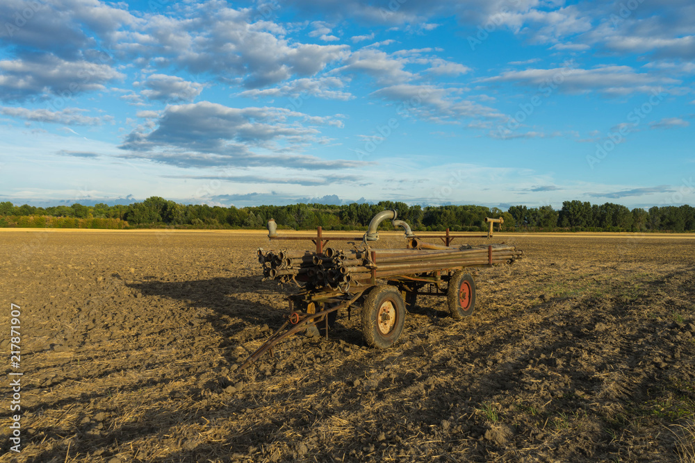 Fototapeta premium pipes for field irrigation on a wagon on a field in rheinhessen