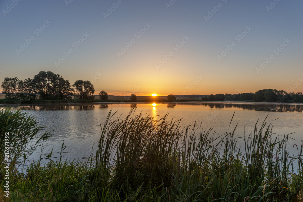 Beautiful sunrise in the summer by the lake. Saxony in Germany