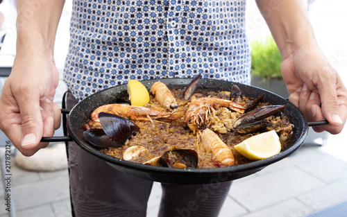 man with a typical spanish seafood paella