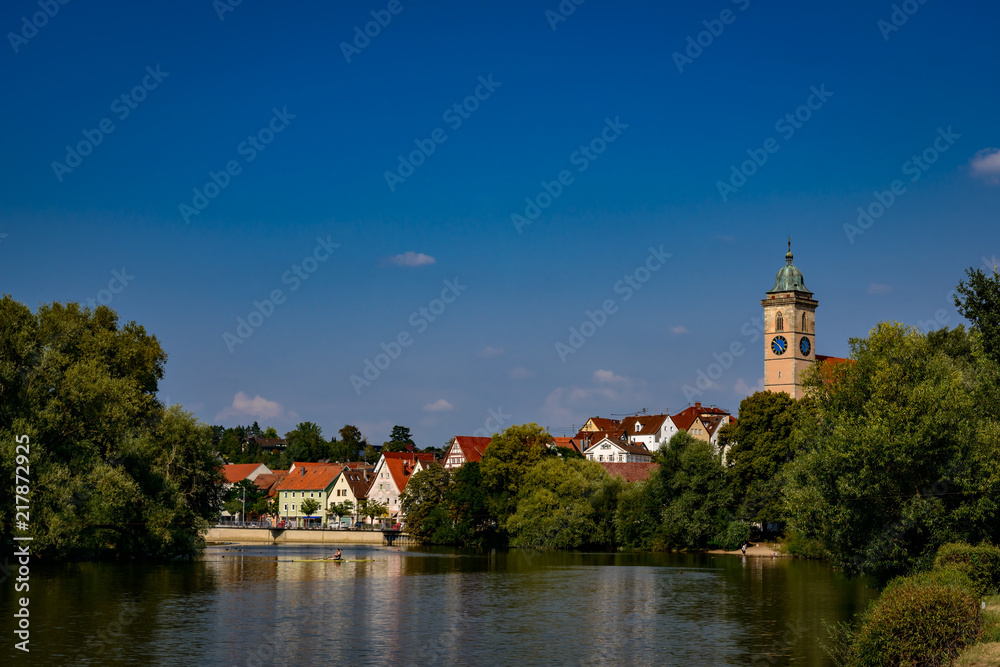 Ruderboot auf dem Neckar vor der Kulisse der historischen Altstadt von Nürtingen mit dem Turm der St. Laurentius-Kirche, Blick von Westen