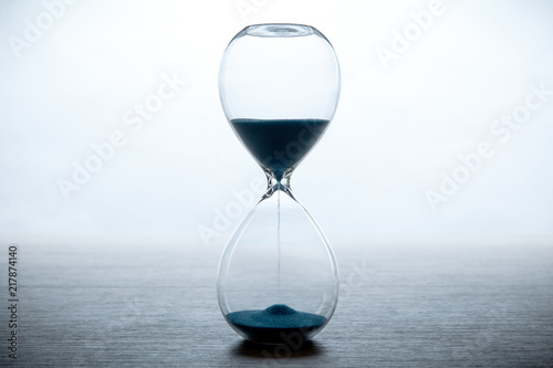 hourglass on a white background and a gray table © mizar_21984