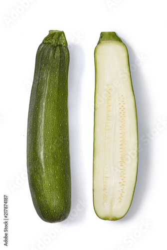 Whole and half of a zucchini isolated on white background. Top view.