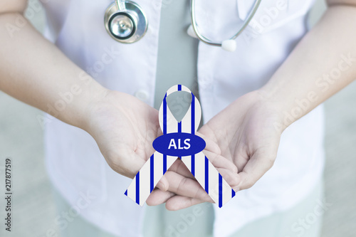 Doctor in white uniform with clinical stethoscope hold stripe blue and white ribbon awareness with text Stop ALS in hand for ALS or Amyotrophic Lateral Sclerosis Awareness photo