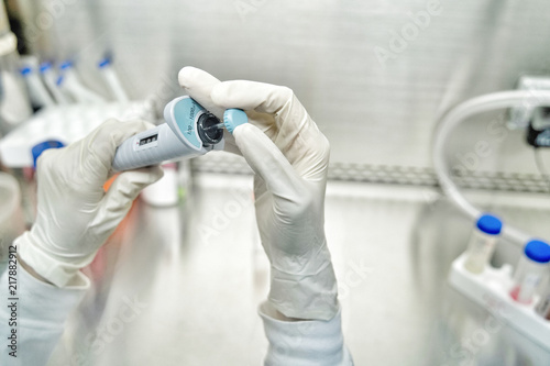 The woman researcher tuning pipette size by hands with gloves before use in the lab test in the laboratory room.