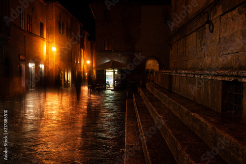 Old European illuminated street at rainy night