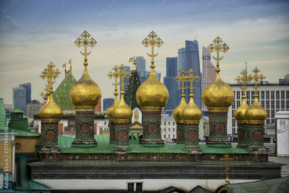 Obraz premium old domes of the temple against the background of a modern city