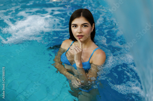 The sexual girl stands in the  swimming pool