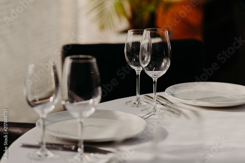 Festive decorated served dinner table with cutlery with noone. Table setting in cafe or restaurant. Light colours. Wedding decor in banquet hall