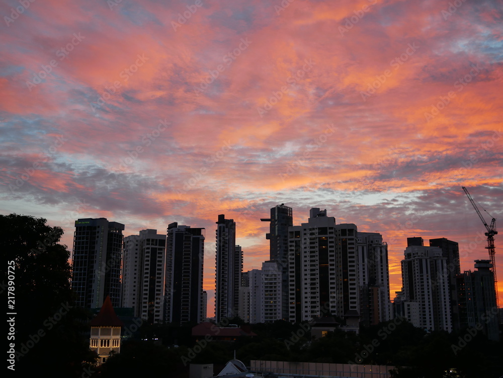 Sunset behind buildings with beautiful cloudy sky