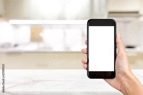 Mobile phone with empty screen on blurred kitchen background