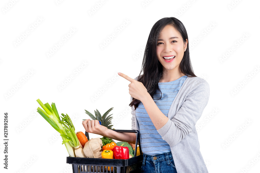 Asian woman holding shopping basket full of vegetables and groceries Asian woman holding shopping basket full of vegetables and groceries